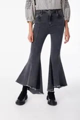 Pantalón de jean elastizado negro con corte acampanado y volados en el ruedo.