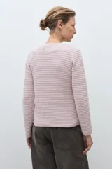 Chaqueta de punto color celeste claro, de manga larga y corte ajustado, con cuello redondo y cierre frontal de botones metálicos plateados. El tejido presenta un patrón texturizado horizontal.