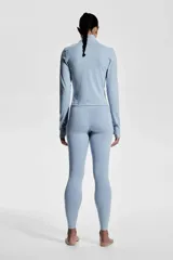 Campera deportiva corta celeste con cuello alto, cierre frontal, mangas largas con orificios para los pulgares y tecnología SoftMove™ y DryMove™.