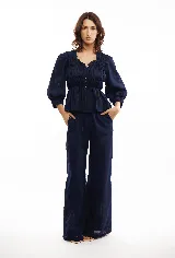 Blusa marrón de lino liviano con escote en V, abotonadura frontal y mangas 3/4 con puño. Diseño con frunces que generan un efecto entallado en la parte superior y amplio en el ruedo.