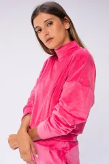Buzo fucsia de terciopelo, con cuello alto y mangas largas.