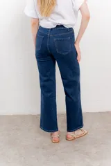 Pantalón de jean azul con corte recto y apliques de strass en líneas verticales.