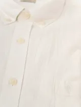 Camisa de manga corta color blanco, confeccionada en lino y poliéster, con cuello abotonado y bolsillo en el pecho con logo bordado. Corte clásico.
