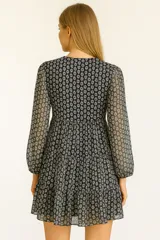 Vestido corto con estampado de hojas, escote en V y mangas largas.