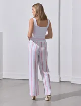 Pantalón de lino a rayas verticales color beige y blanco, con pretina ancha elastizada, lazo de ajuste y bolsillos inclinados.