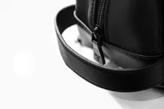 Neceser negro rectangular con cierre superior y logo de la marca en el frente.