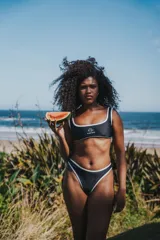 Bikini negro con ribetes blancos, compuesto por un corpiño deportivo con logo y una bombacha de corte clásico.