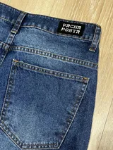 Bermuda de jean azul oscuro con lavado, corte muy ancho y largo hasta la mitad de la pantorrilla.