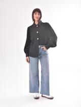 Camisa verde oliva con rayas verticales en relieve, corte clásico, cuello camisero, cierre frontal con botones blancos, mangas largas abullonadas con puños elastizados.
