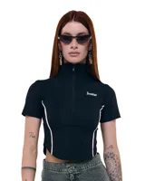 Top cropped negro de gabardina elastizada, con cuello alto, cierre frontal, silueta entallada, recortes y costuras a contratono.