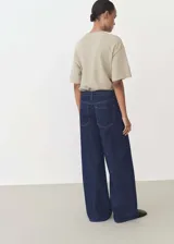 Pantalón de jean azul oscuro, de corte wide leg, tiro bajo y cintura con cordón ajustable.