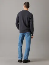 Sweater gris oscuro de punto de algodón con cuello redondo, puños y bajo acanalados. Presenta el logo de Calvin Klein bordado en el pecho.