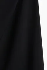 Vestido corto negro de breteles finos, escote cuadrado, corte ajustado y frunces laterales que generan un efecto drapeado en la falda.