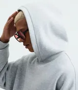 Buzo con capucha y bolsillo canguro delantero, color gris melange, de corte recto y holgado.