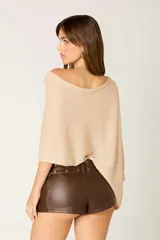 Poncho color beige de tejido liviano con destellos sutiles.