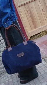 Bolso de viaje color verde oliva con detalles en cuero marrón.