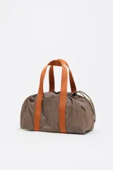 Mini bolso de nylon color marrón con asas de mano naranjas y cordones ajustables verdes. Incluye logo metálico de Bimba y Lola y bolsillo interior.