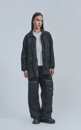 Campera negra oversize con broches en el delantero, forrada con red, múltiples bolsillos con detalles réflex y puños elásticos.