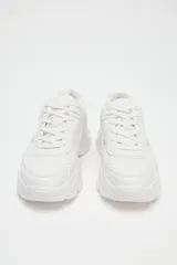 Zapatillas deportivas blancas con plataforma chunky, detalle de pespuntes y cierre con cordones.