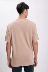 Remera color visón de corte amplio con estampa pequeña en el pecho.