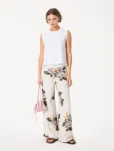 Pantalón de punto color gris con estampado de flores, cintura elastizada, corte amplio y broches laterales en el ruedo.