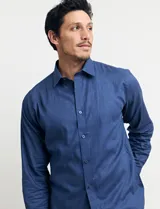Camisa celeste de manga larga con cuello button-down, confeccionada en tejido rústico de algodón y lino.