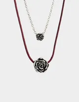 Set de dos collares cortos, uno con cadena plateada y dije de rosa plateada, y otro con cordón color borgoña y dije de rosa plateada.