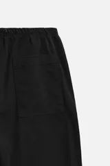 Pantalón de hombre color beige, corte carrot fit, con cintura elástica ajustable con cordón, bolsillos frontales y bolsillo trasero de plastrón.