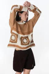 Sweater azul con cuello redondo y diseño de cuadrados de crochet en la parte inferior.