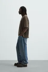 Camiseta marrón de corte holgado, cuello redondo y manga corta. Tiene un efecto lavado y terminaciones irregulares.