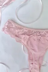 Colaless de tiro alto, confeccionada en algodón elastizado rosa con detalles de puntilla en los laterales y el borde superior.