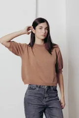 Sweater color dorado de tejido de punto suave con hilos metalizados, corte recto y mangas cortas con puño ajustado.