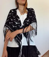 Chal negro tejido a mano con diseño calado y flecos en la terminación.