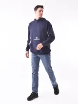 Buzo hoodie color petróleo con bolsillo tipo canguro y estampado blanco con forma de globo terráqueo y texto.