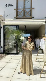 Vestido largo color beige, confeccionado en lino, con cuello camisero, mangas 3/4 y falda amplia con alforzas.