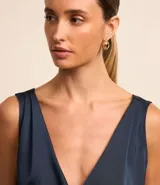 Body sin mangas color azul marino, confeccionado en tejido satinado, con escote en V cruzado en el frente y en la espalda.