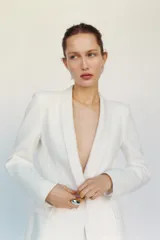 Blazer blanca entallada con cuello solapa combinado, manga larga con hombreras, bolsillos de plastrón en delantero, costuras marcadas, forro interior a tono y cierre frontal con botón forrado.