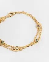 Pulsera dorada de doble cadena con eslabones y dijes de piedras de fantasía redondas con efecto tornasol.
