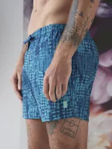 Short de baño color borgoña con estampado de hojas en tono sobre tono, cintura elástica con cordón ajustable y logo de la marca en la pierna.