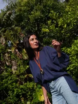 Camisa verde agua de lino, con botones de guampa, más larga atrás que adelante y espalda con tajo en el medio.