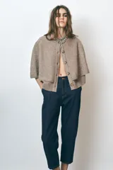 Pantalón de jean azul oscuro, corte carrot, tiro medio, largo cropped, con cintura elástica en la parte trasera, bolsillos delanteros y traseros, cierre con cremallera y botón.