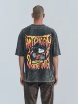 Remera negra con efecto nevado, corte oversize y estampado de Mickey Mouse sobre una patineta.