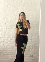 Top negro de microtul con estampado de flores rojas y verdes.