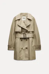 Trench confeccionado en mezcla de algodón color beige. Cuello solapa de muescas y manga larga ajustable con trabillas y botón. Bolsillos en delantero. Cinturón en mismo tejido ajustable con hebilla. Detalle de trabillas en hombros. Cierre frontal cruzado con botones.