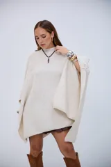 Poncho de punto color crudo, con cuello redondo y diseño holgado.
