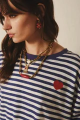 Remera de manga larga confeccionada en algodón a rayas horizontales azul marino y blanco. Tiene un pequeño bordado de corazón rojo en el frente y cuello redondo.