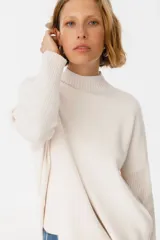 Sweater negro de textura suave, con mangas de puño y diseño holgado.
