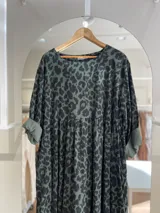 Vestido verde con estampado animal print, corte oversize, mangas 3/4 con puños arremangados y falda con frunce.