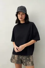 Remera negra de corte cuadrado con cuello redondo y mangas cortas con dobladillo.