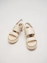 Sandalias negras de cuero con plataforma y taco ancho. Tienen correa trasera con elástico y doble argolla en la parte externa e interna.